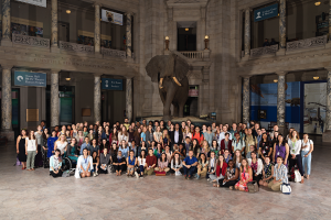 A group of interns stand before Henry the Elephant in the Natural History Museum.