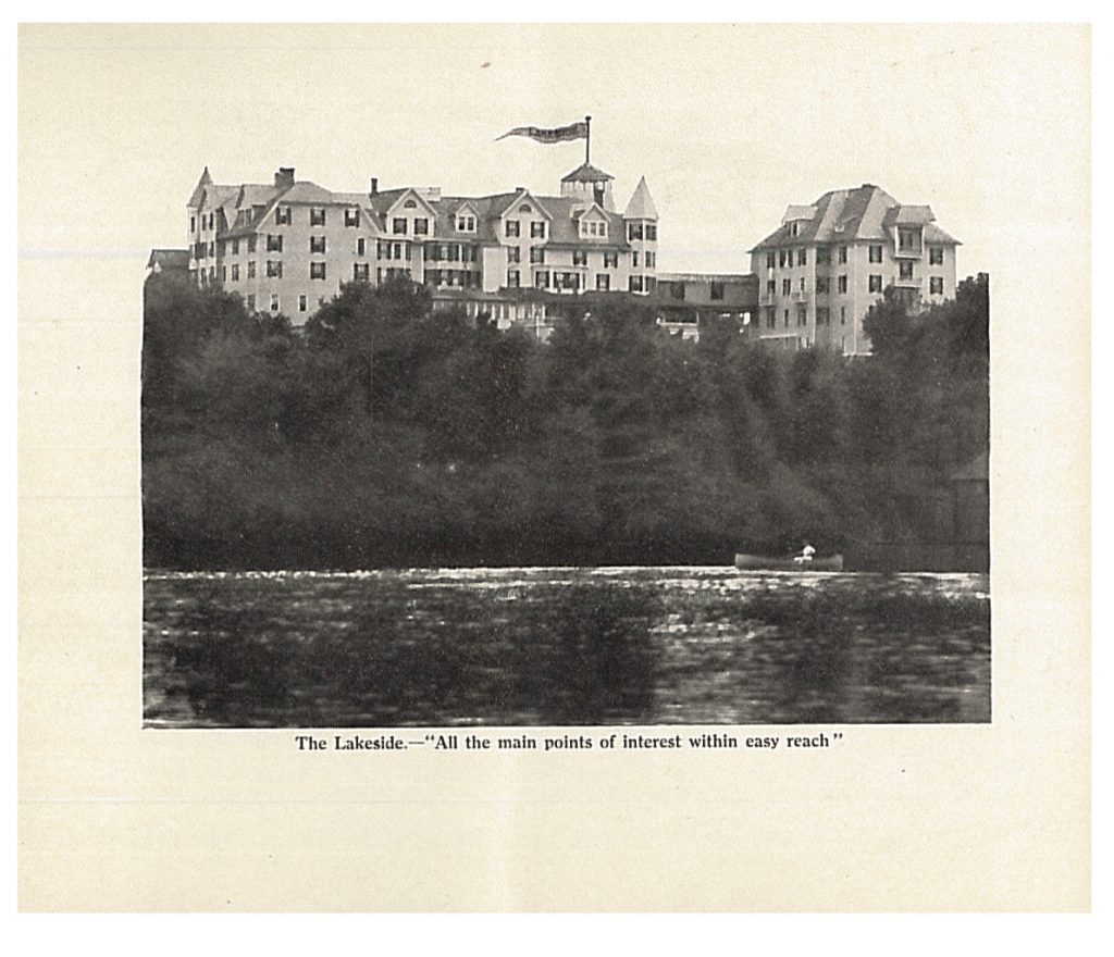 view of a boat on the lake with Lakeside in the background behind trees