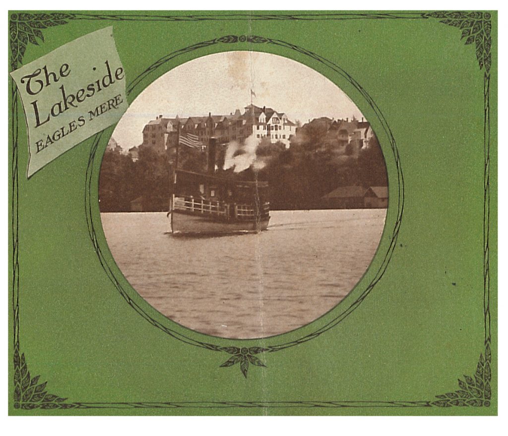 a boat on the lake with the Lakeside in the background