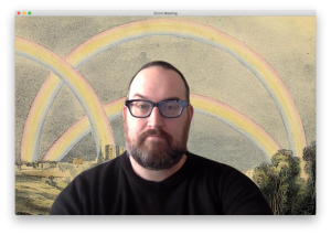 Screenshot of man in foreground with digital background of rainbows. 