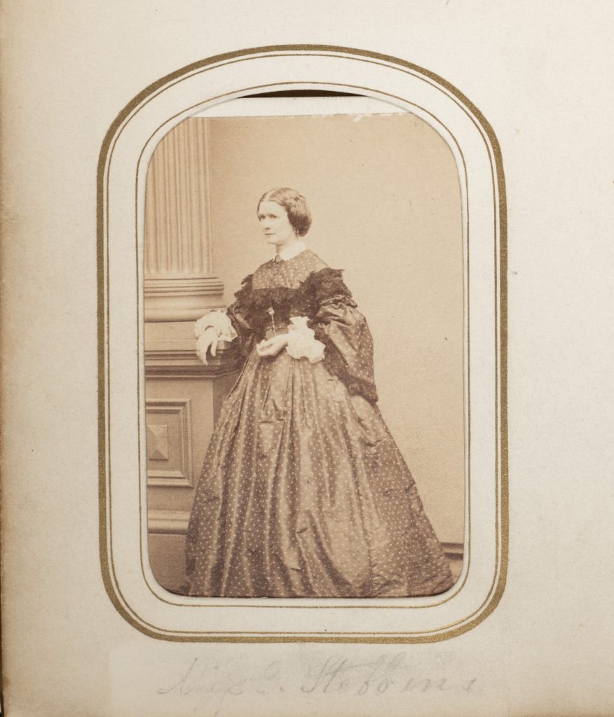 Carte de VIsite of Emma Stebbins. 19th century photography of Caucasian women standing in dark hoop skirt dress. 