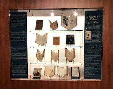 Photo of books on display in lighted case. 