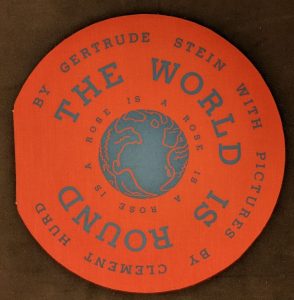 Photo of a round, pink-red book "The World Is Round"