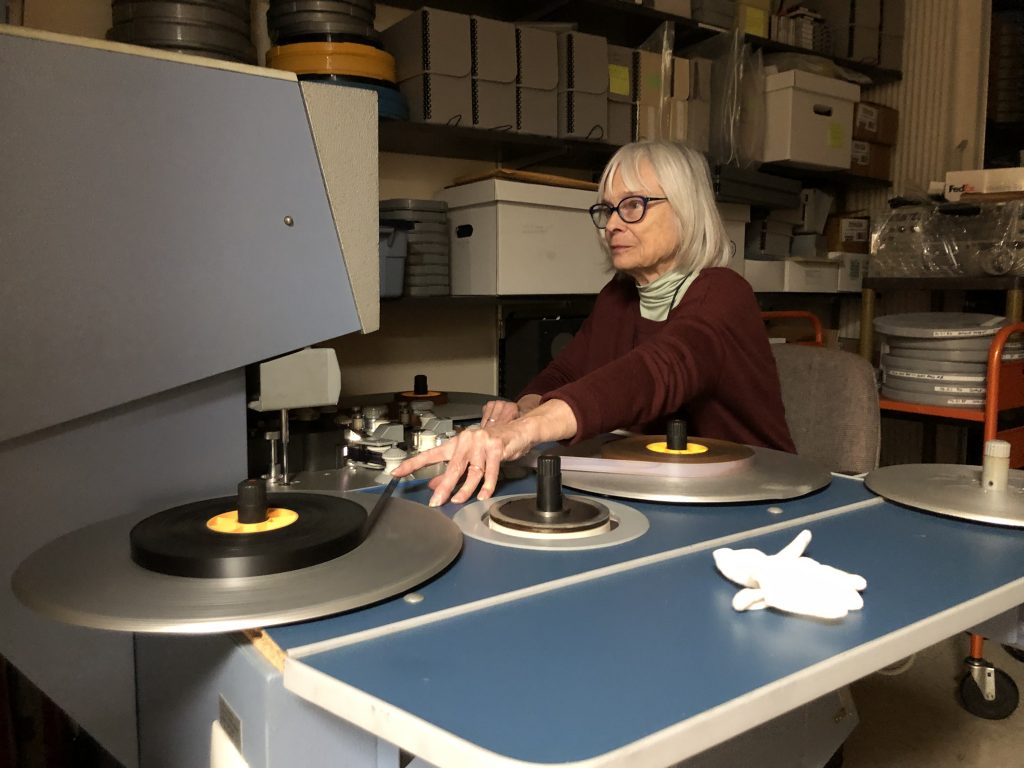 Pam Wintle stares at a screen projecting film being played back on a flatbed editing machine.