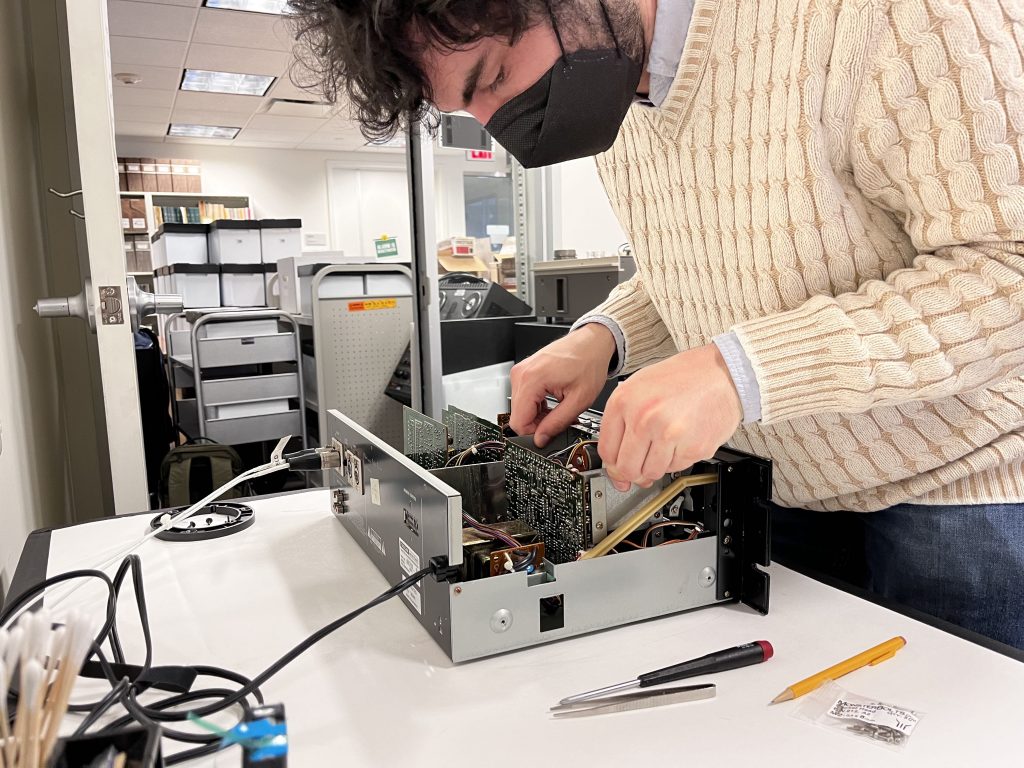 Dan Hockstein stands over a dissasembled cassette deck.