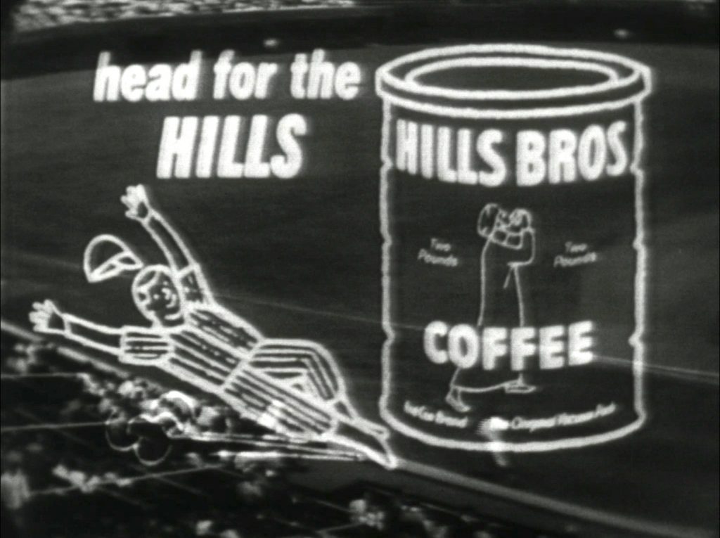 Superimposed over the live feed background of ballpark Wrigley Field, a caricature baseball player slides into a coffee can of Hills Bros. Coffee. Text reads: head for the HILLS.