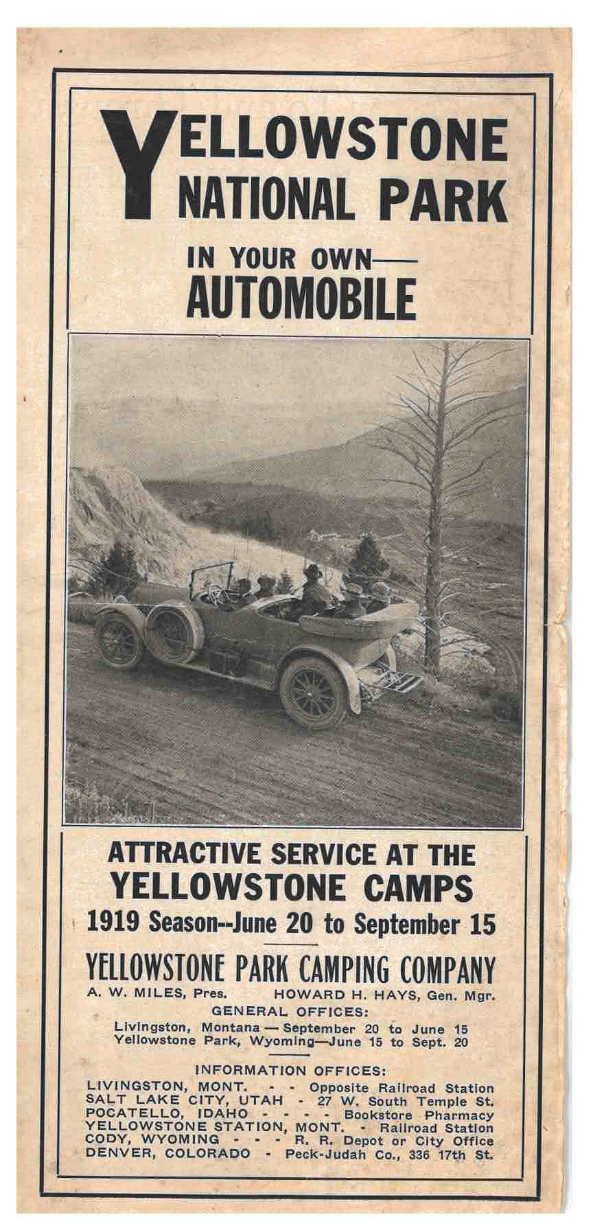 five people in an automobile driving along a scenic road with mountains in the background